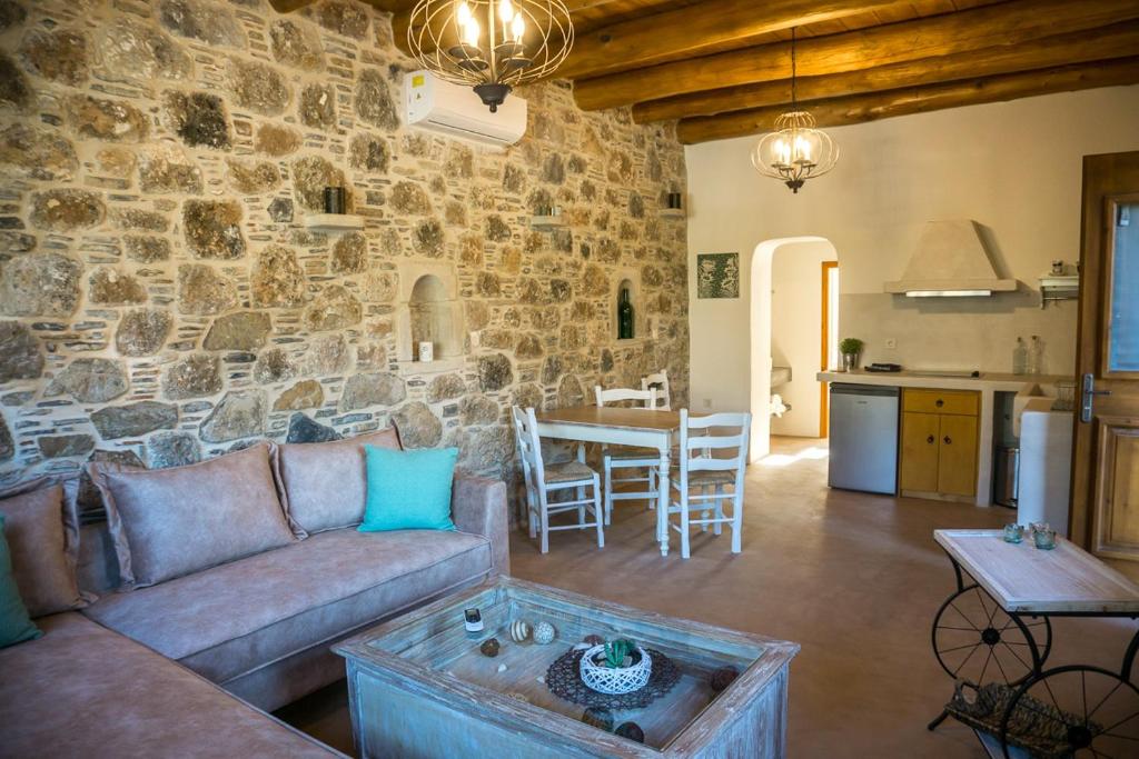 a living room with a couch and a stone wall at To Spiti mas in Sougia