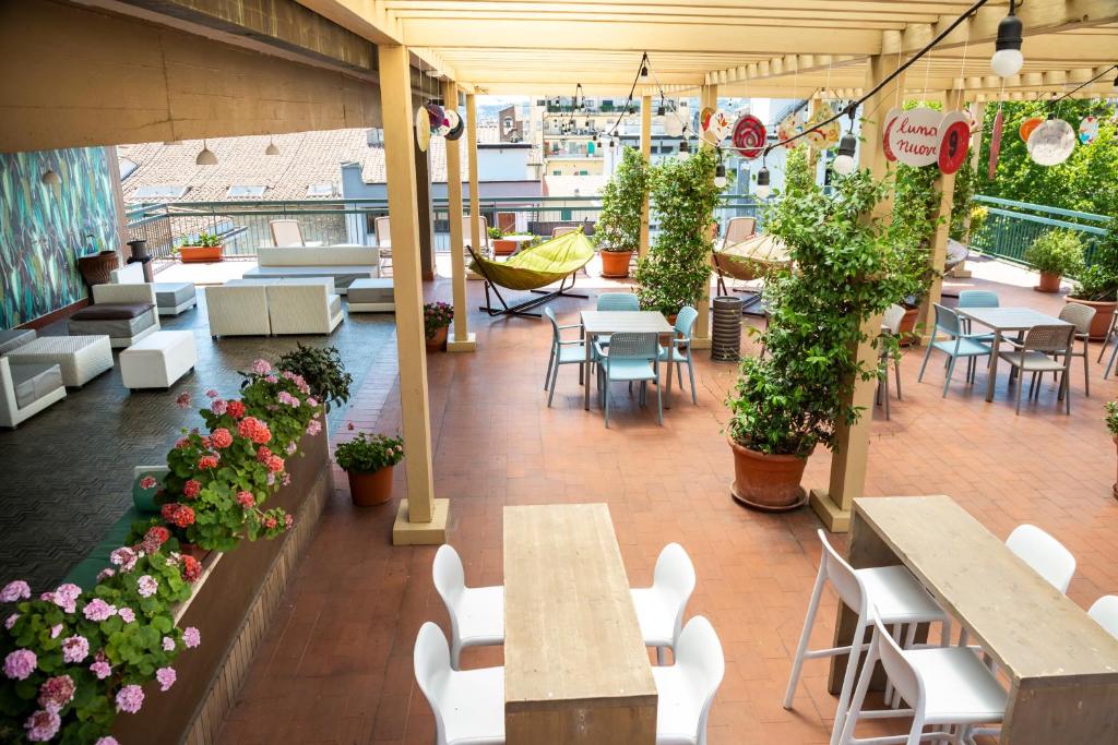 an outdoor patio with tables and chairs and flowers at Plus Florence in Florence