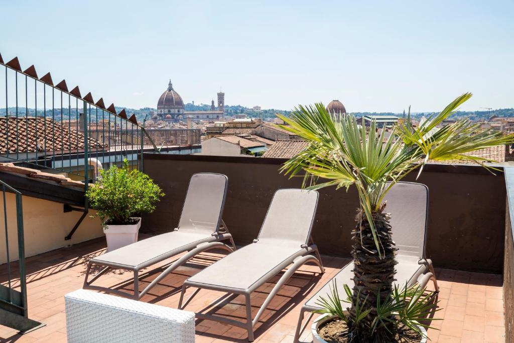 un balcón con sillas y una palmera en el techo en Plus Florence, en Florencia