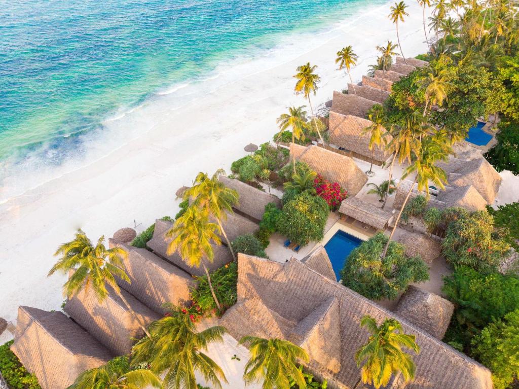 - une vue aérienne sur une plage avec des palmiers et des cabanes dans l'établissement Zanzibar Sunrise at Bandas, à Matemwe