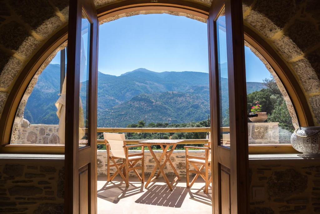 an open door to a balcony with a table and chairs at To Spiti mas in Sougia