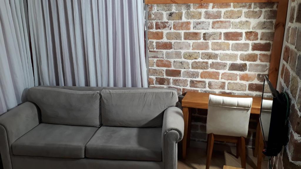 uma sala de estar com um sofá e uma parede de tijolos em suit cihangir em Istambul