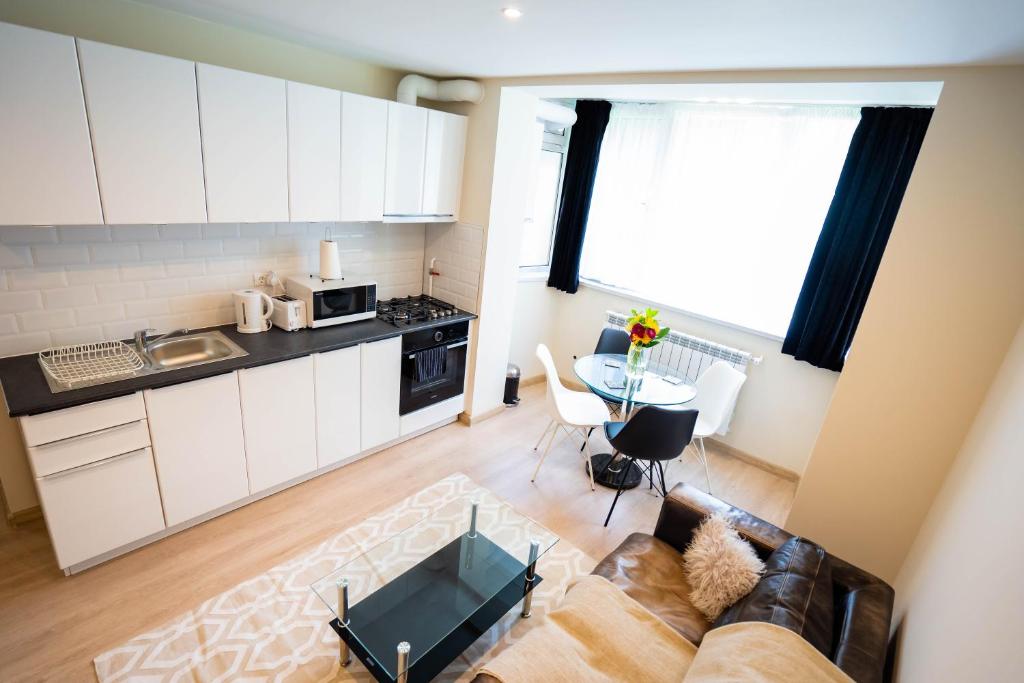 a kitchen and living room with a couch and a table at Cris Apartament in Suceava