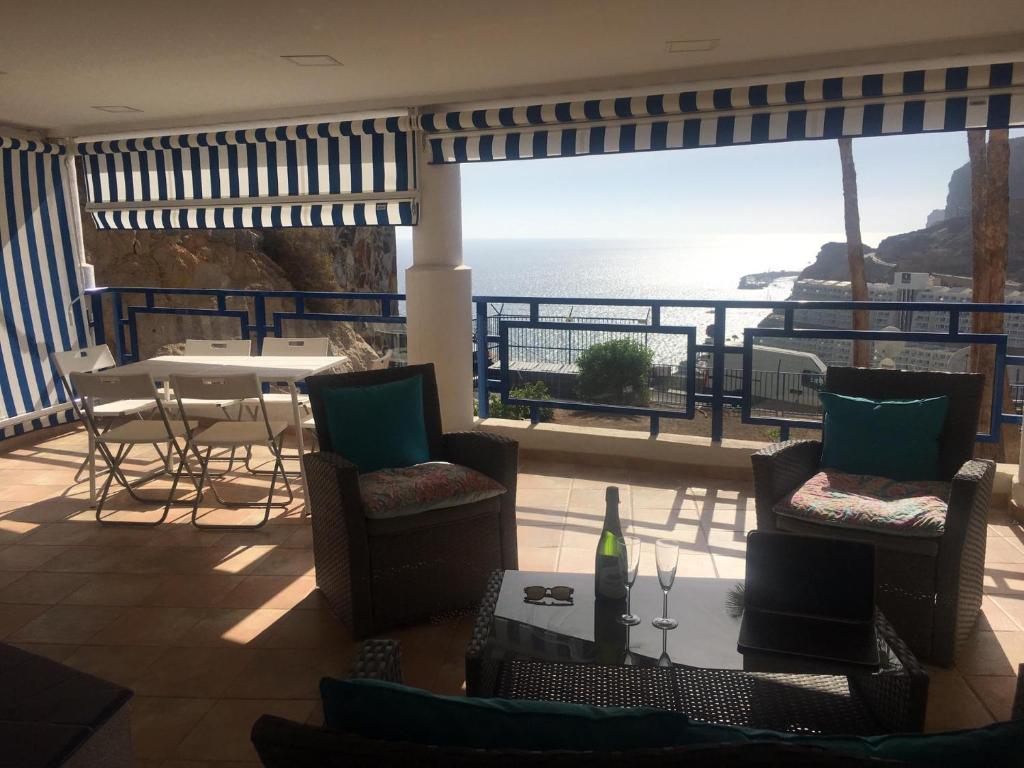 balcón con mesa, sillas y vistas al océano en Vistataurito en Mogán