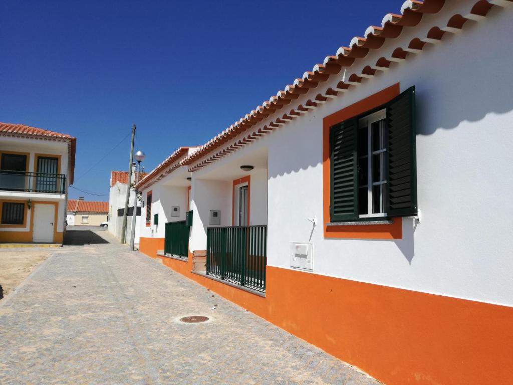 una fila di edifici bianchi e arancioni con finestra di Casa Pompona 3 a Rogil