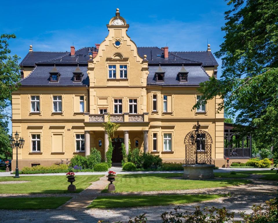 a large yellow mansion with a clock tower at Pałac Gruszów in Świdnica