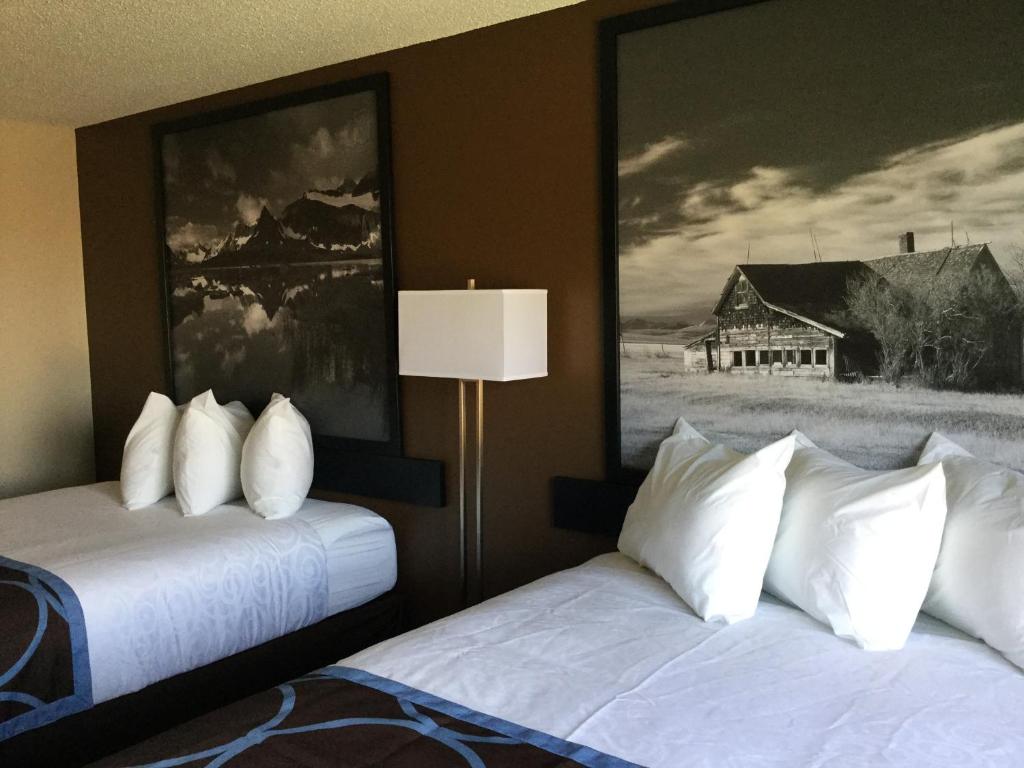 a hotel room with two beds and a painting on the wall at Super 8 by Wyndham Spruce Grove in Spruce Grove