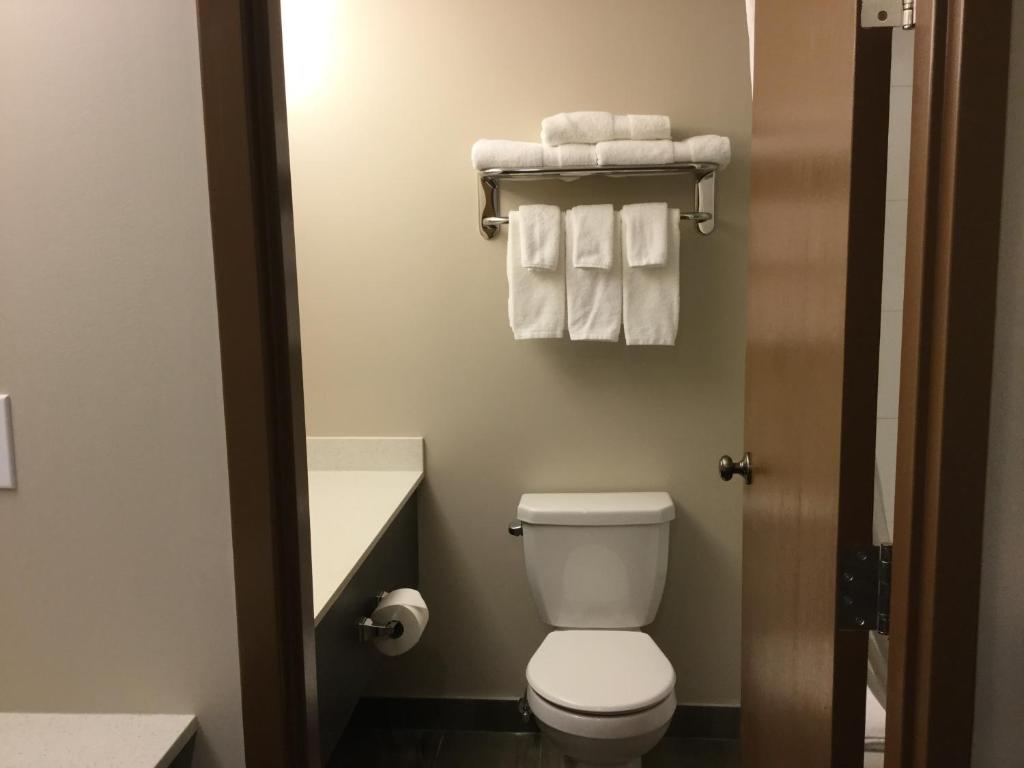 a small bathroom with a toilet and towels at Super 8 by Wyndham Spruce Grove in Spruce Grove