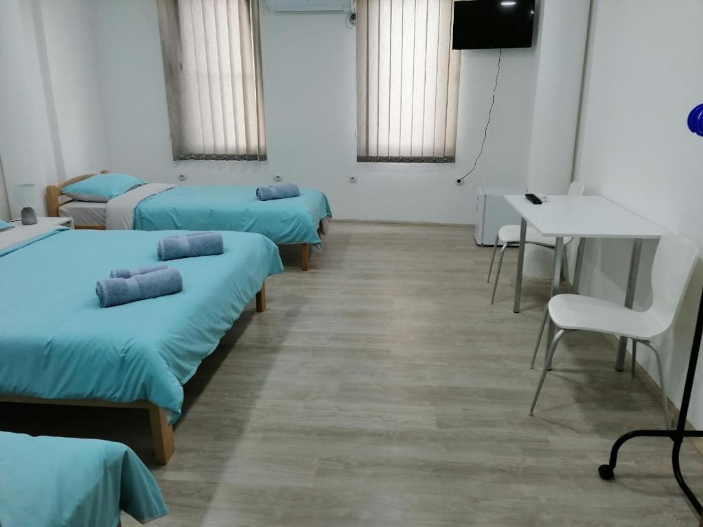 um quarto com quatro camas e uma mesa e cadeiras em Ljupco Apartments em Gevgelija