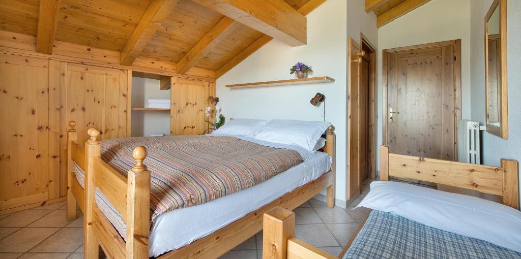 sypialnia z łóżkiem w pokoju z drewnianymi ścianami w obiekcie Hotel Gallo Cedrone w mieście Valdisotto