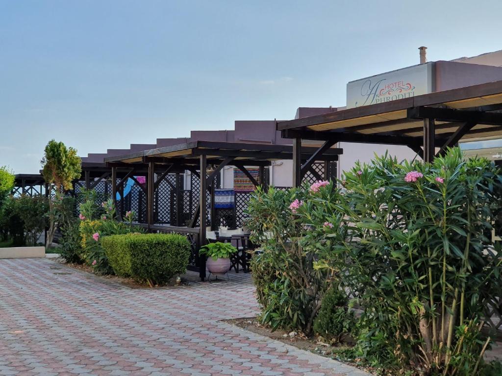 un patio con un montón de plantas y sombrillas en Hotel Aphroditi Island Park, en Alexandroupoli