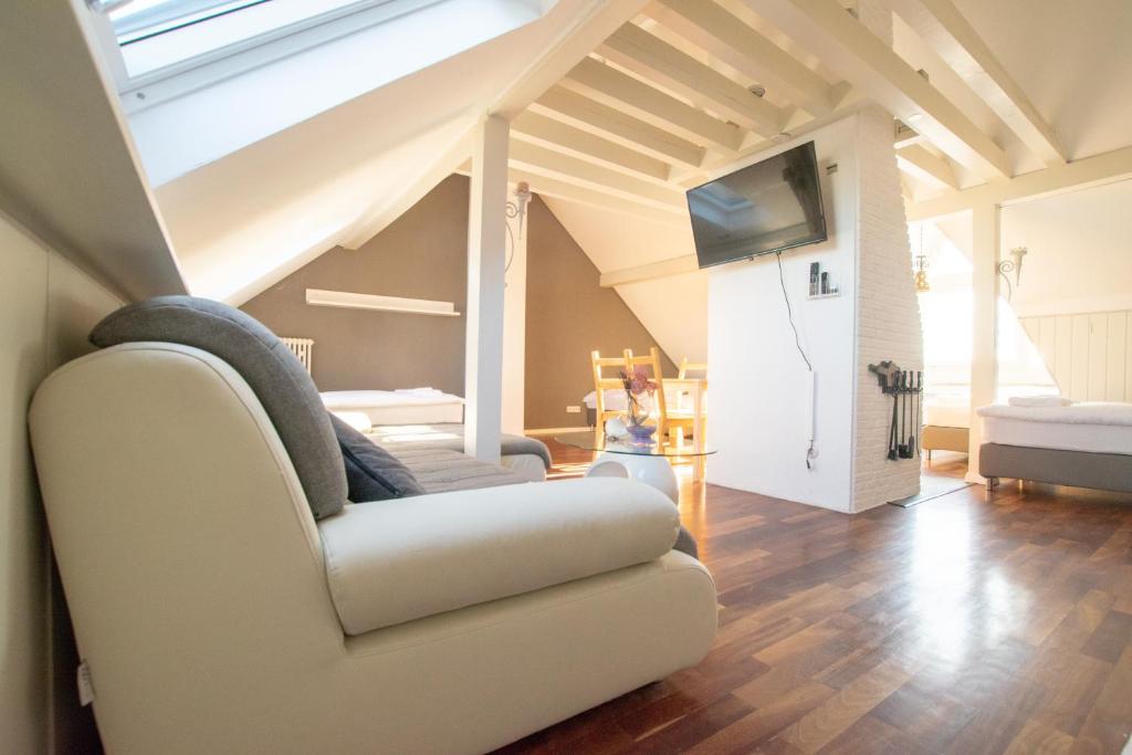 a living room with a white couch and a tv at Lovely City House in Meerbusch