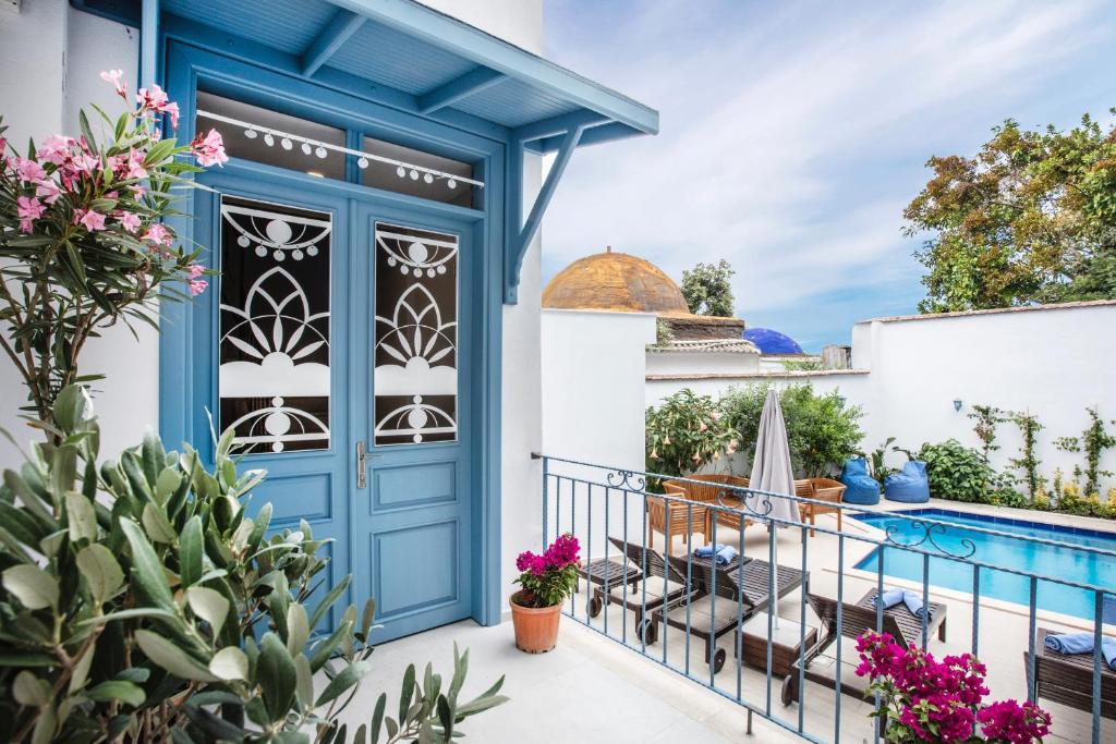 una puerta azul en un balcón con plantas y flores en Eliada Hotel en Kusadasi