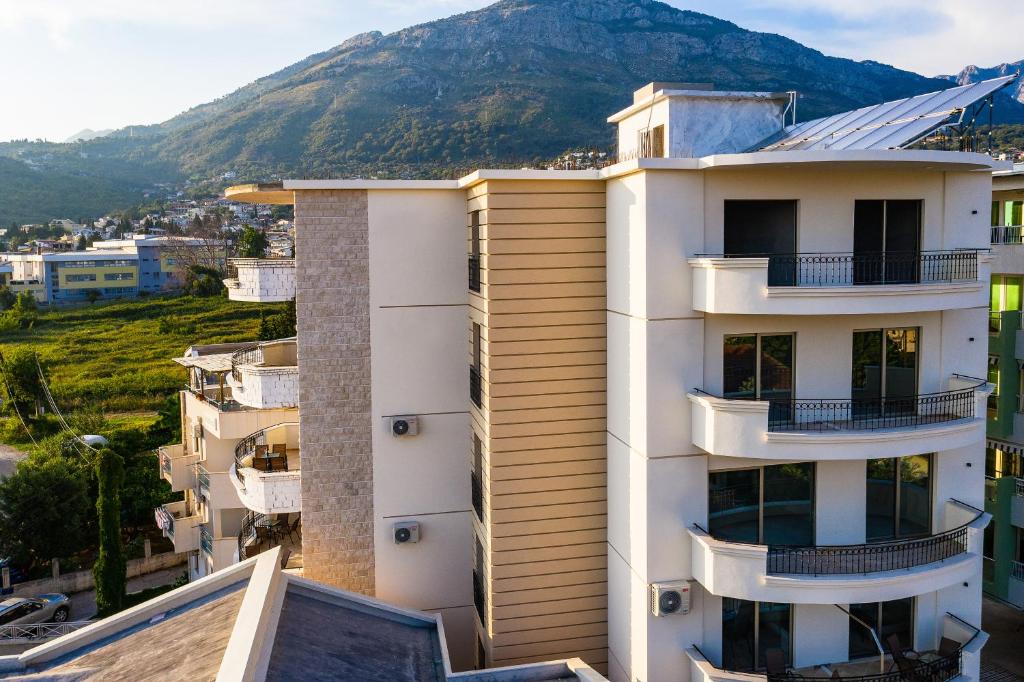a building with a mountain in the background at Apolon Apart in Bar, Susanj