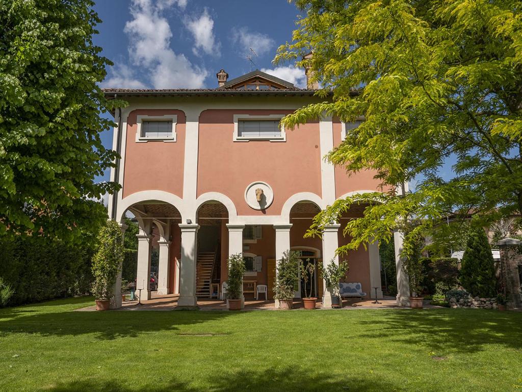 a large house with a green lawn in front of it at Villa Matildis in Modena