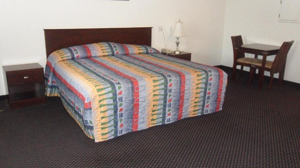 a bedroom with a bed with a colorful comforter at Deluxe Inn Palacios in Palacios