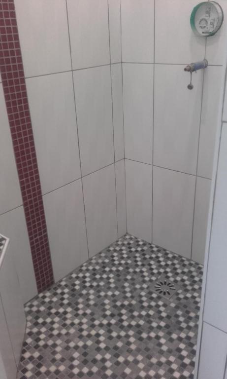 a white shower with a black and white tile floor at Chambre d&#39;hôte du HOUSSAY in Valennes