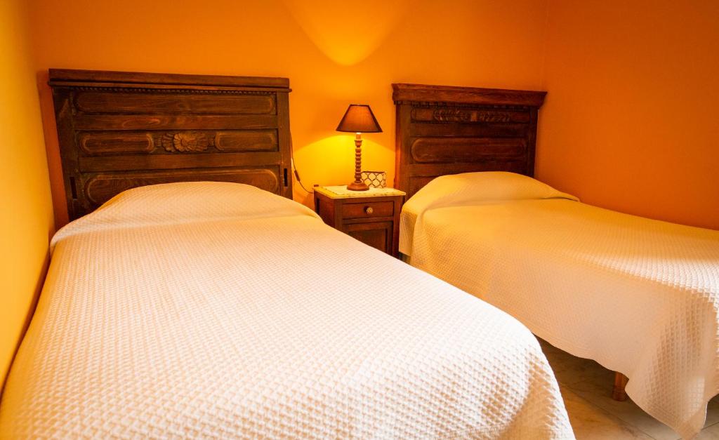 ア・エストラーダにあるCasa da Pastoraのベッドルーム1室(ベッド2台、ランプ付きテーブル付)