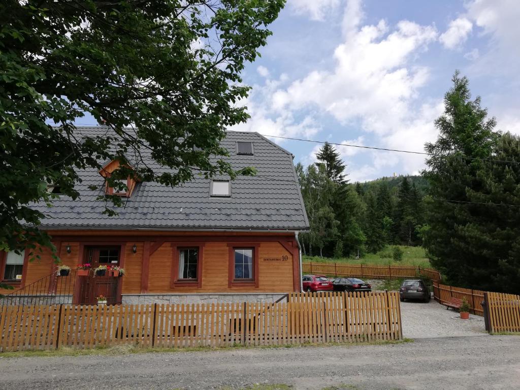 une maison en bois avec une clôture devant elle dans l'établissement Willa Marzenie, à Szklarska Poręba