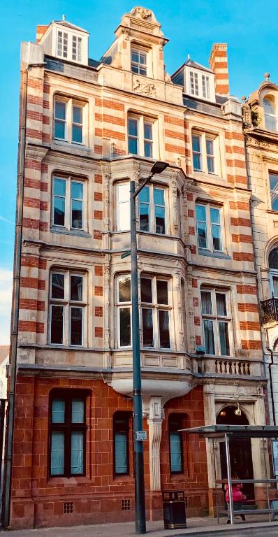 a large brick building on the corner of a street at City Centre Mansion Sleeping 1 to 23 in Cardiff