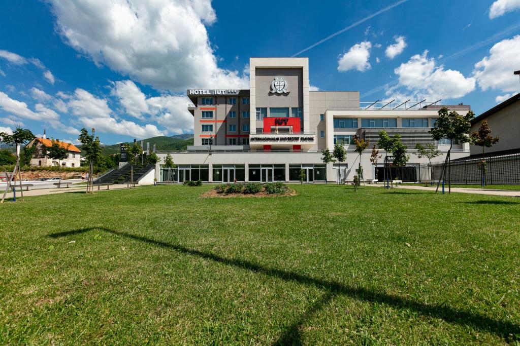 a building with a large lawn in front of it at Hotel IUT in Travnik
