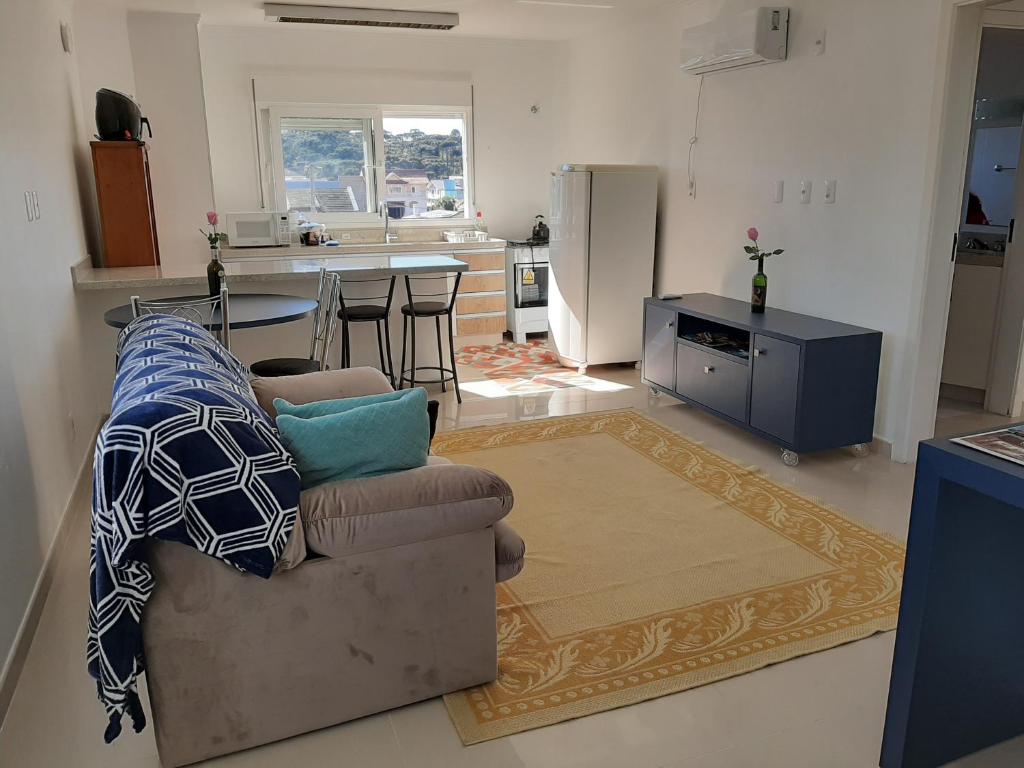 Apartamento Santa Ana في ساو جواكيم: غرفة معيشة مع أريكة ومطبخ