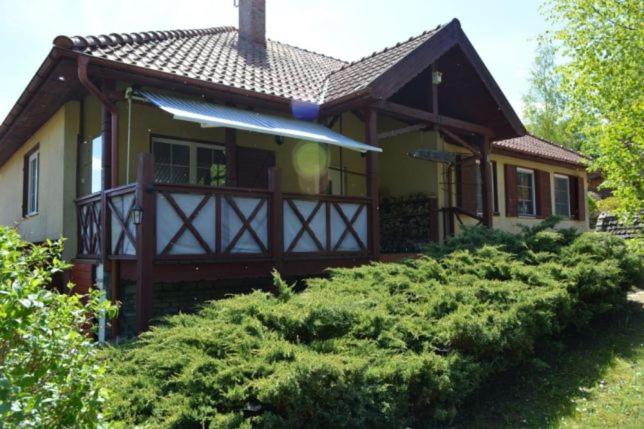 佩茨基的住宿－Cierzpięty 23c，一个小房子,设有门廊和灌木丛