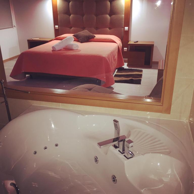 a bathroom with a bath tub in front of a bedroom at Quinta de Real in Valença