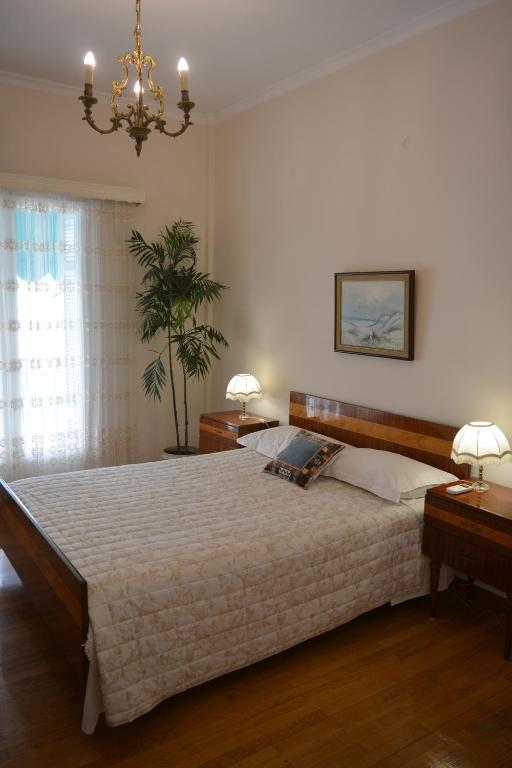 a bedroom with a large bed and a chandelier at ELENI'S NEOCLASSICAL HOME in Athens