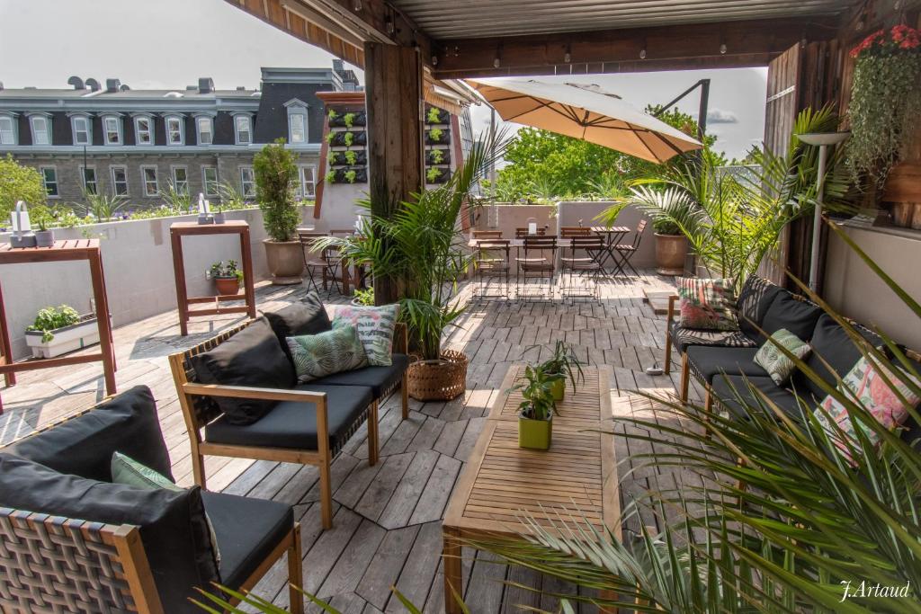 an outdoor patio with chairs and tables and plants at Auberge du Plateau in Montreal