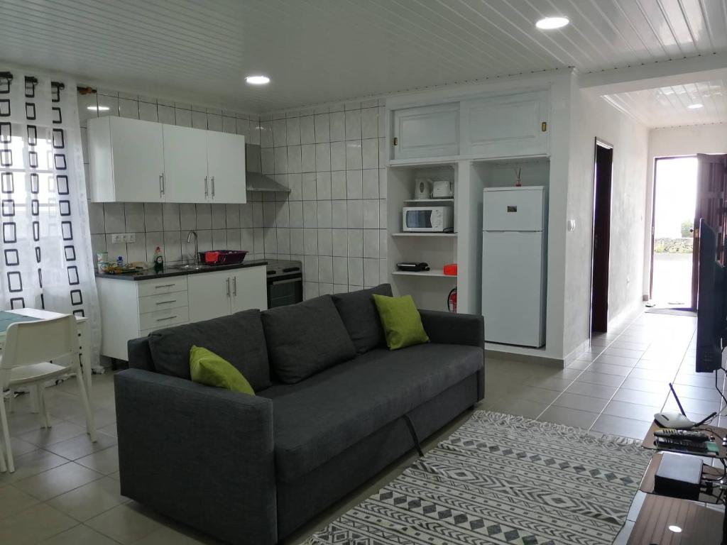 een woonkamer met een bank en een keuken bij Casa da Sogra - Apartamento 3 in Faja Grande