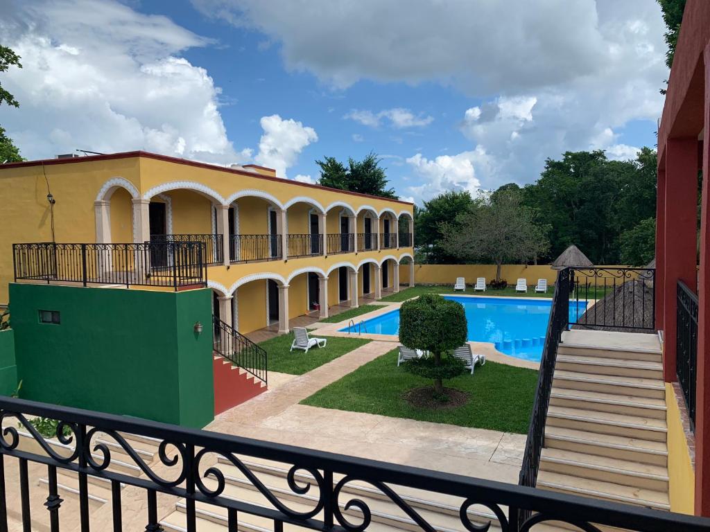 a view of a building with a swimming pool at Hotel Tuul in Izamal