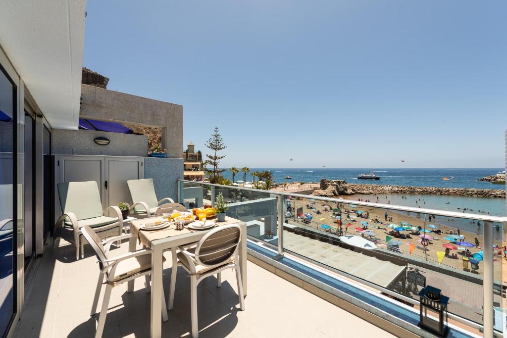 a balcony with a table and chairs and a view of the beach at Amarre Ocean in Puerto de Mogán