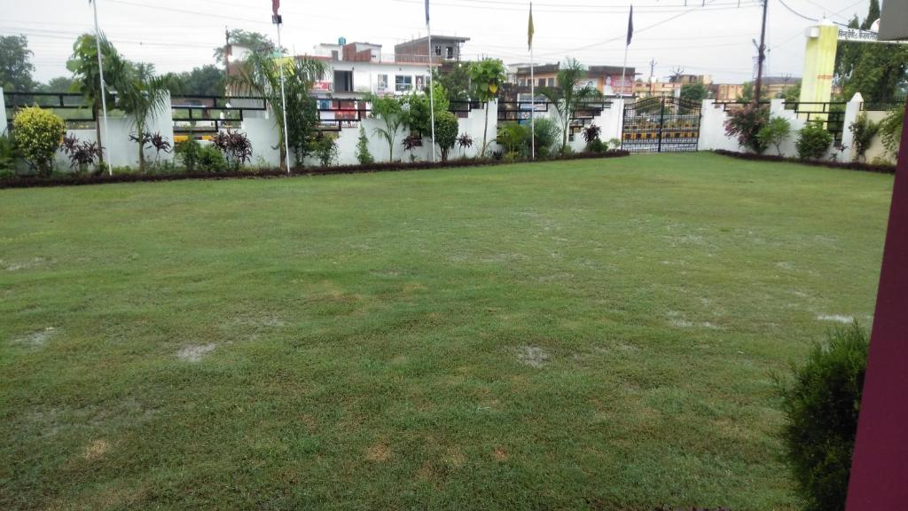 een grote tuin met groen gras en gebouwen bij Hotel the Ideal in Kushinagar