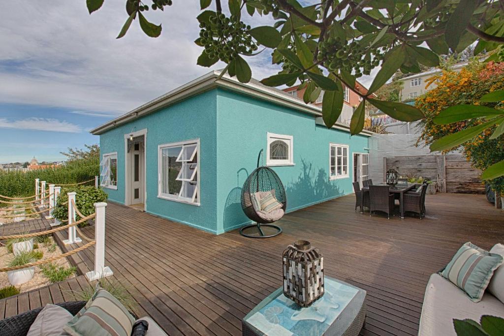 a house with a deck with a blue house at Aqua On Reed in Oamaru