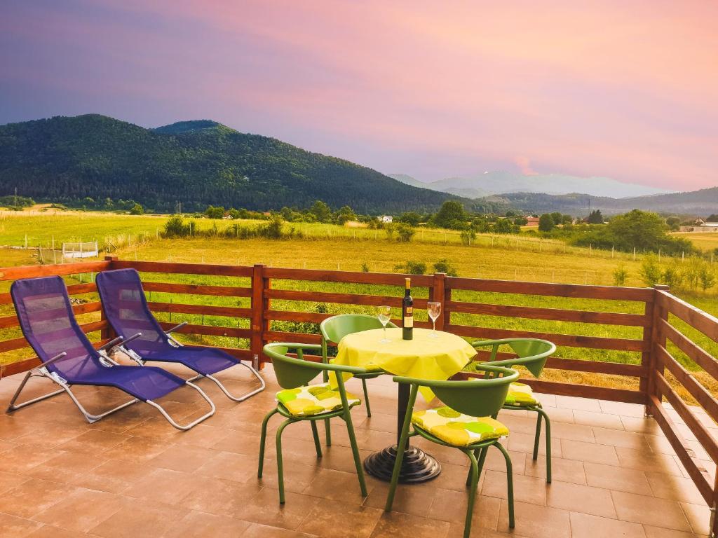 eine Terrasse mit einem Tisch und Stühlen auf einem Zaun in der Unterkunft Apartman Miramare in Otočac