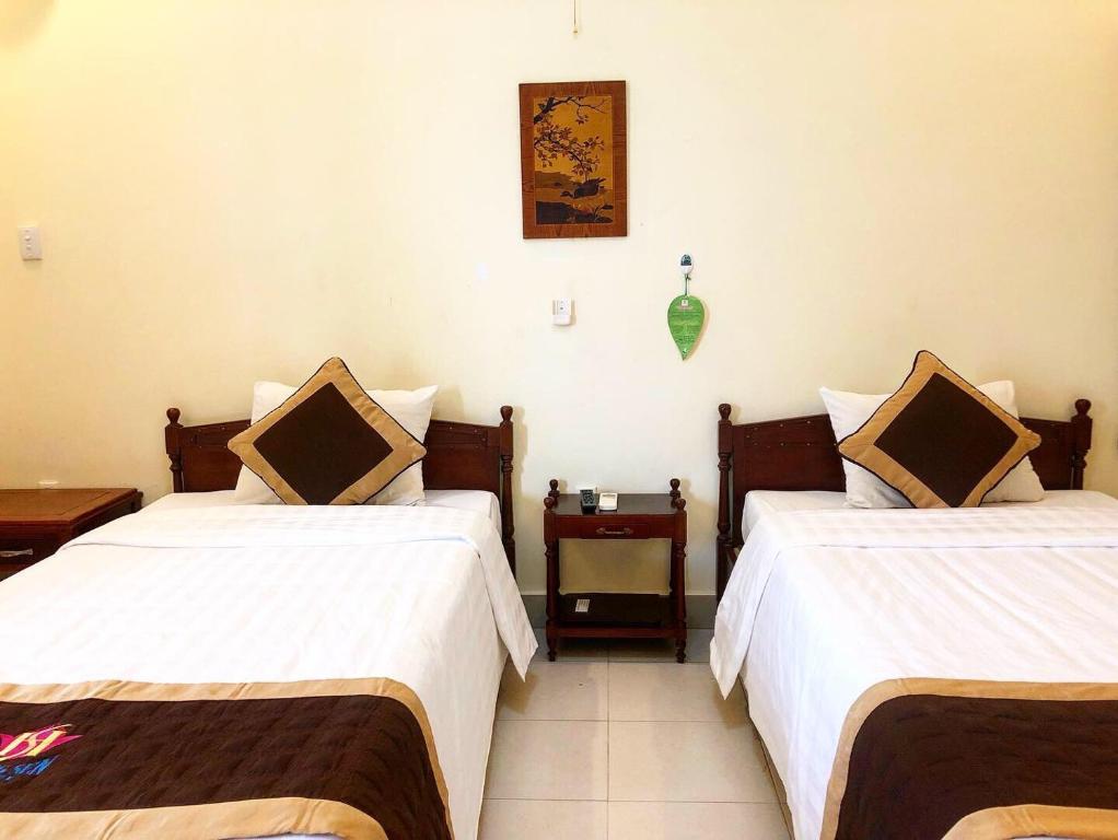 two beds in a hotel room with white sheets at Huong Sen 2 Hotel in Vung Tau