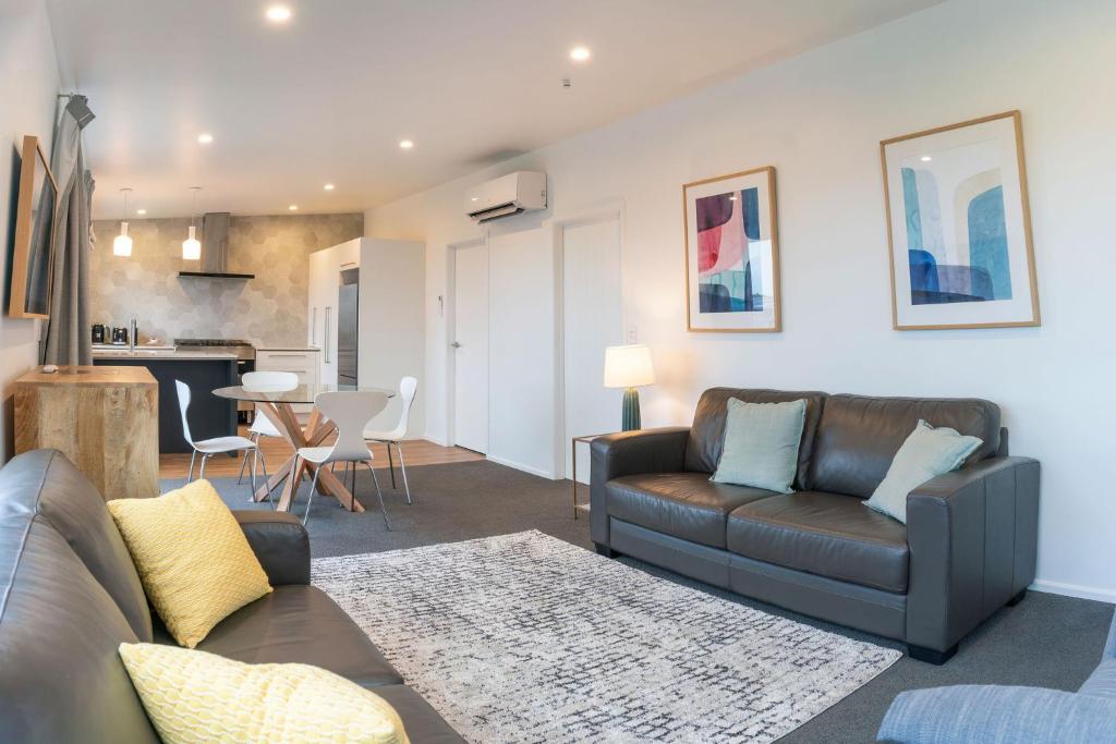 a living room with a couch and a table at The Yellow House in Kaka Point