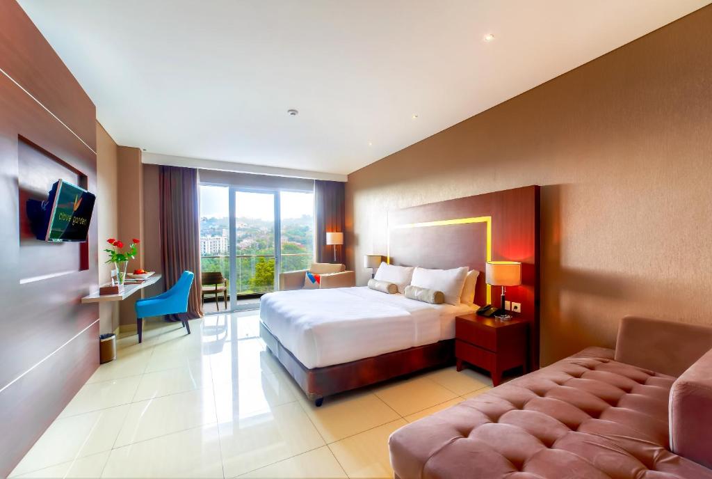 a hotel room with a bed and a couch at Clove Hotel Bandung in Bandung