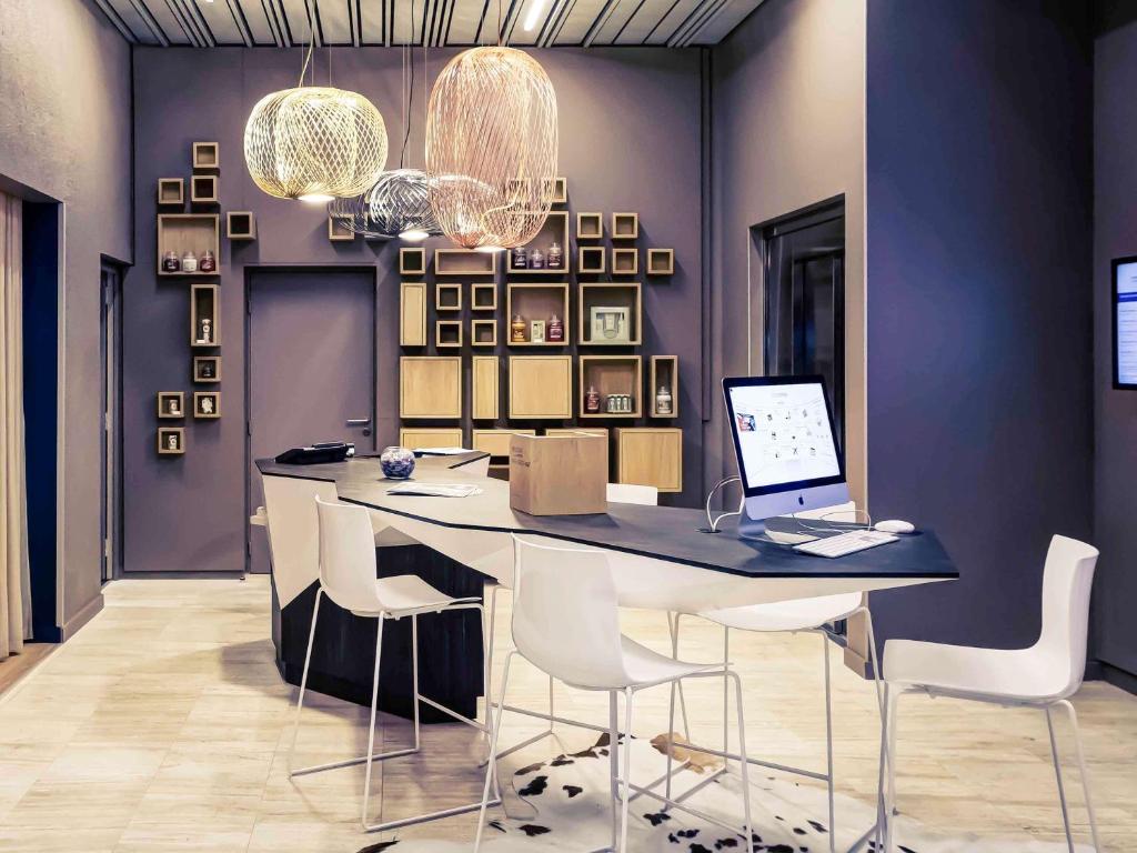 a dining room with a table with chairs and a laptop at Mercure Lyon Charbonnières in Charbonnières-les-Bains