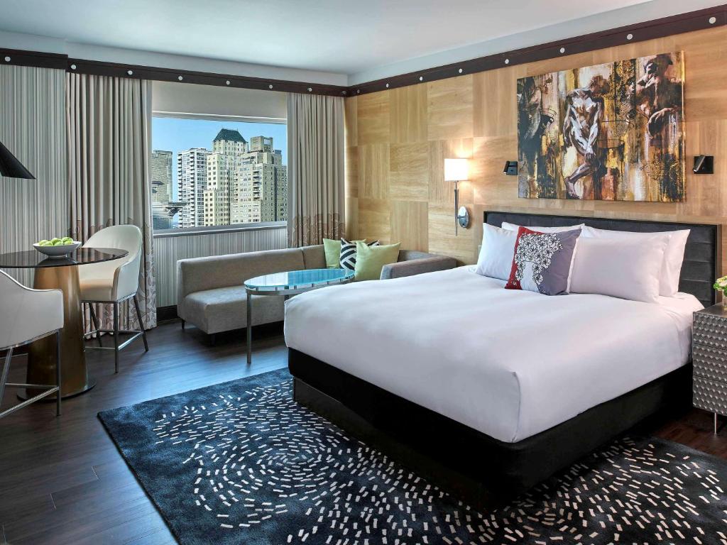 a hotel room with a large bed and a living room at Sofitel Philadelphia at Rittenhouse Square in Philadelphia