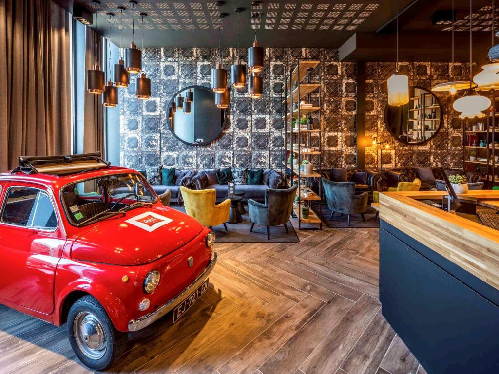 a restaurant with a red car parked in a bar at ibis Le Mans Centre Gare Nord in Le Mans