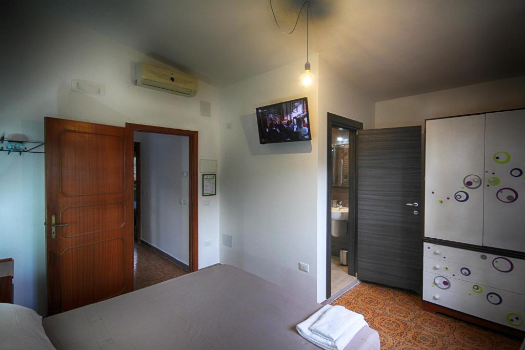 ein Wohnzimmer mit einem Bett und einem TV an der Wand in der Unterkunft Wunderkammer b&b in Pulsano