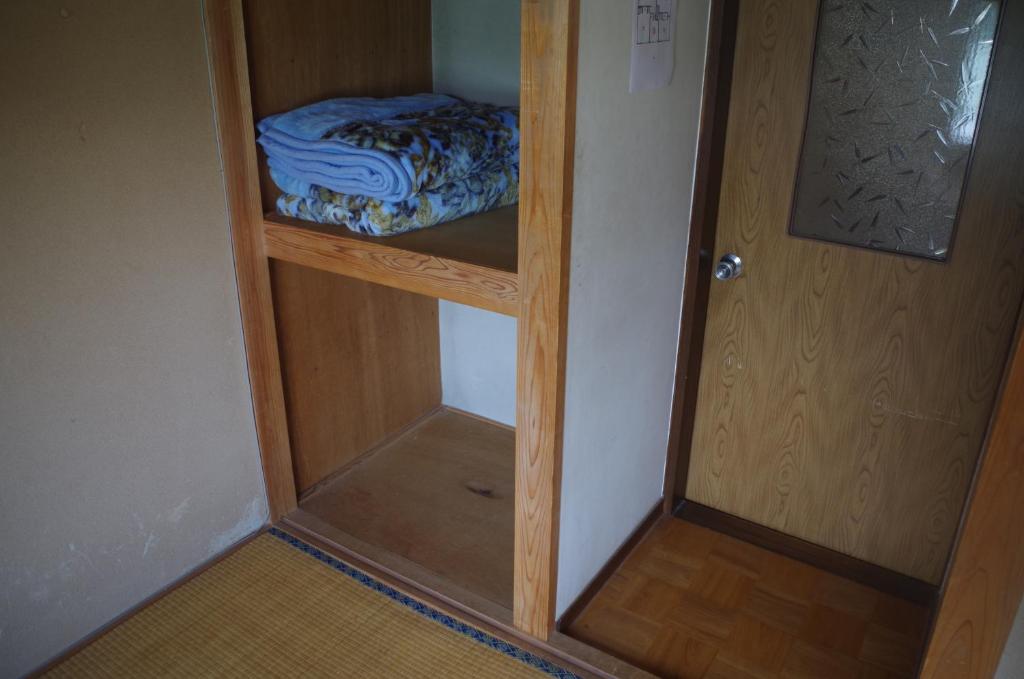 a room with a closet with a bed in it at Kusatsu Onsen Guesthouse Gyoten in Kusatsu