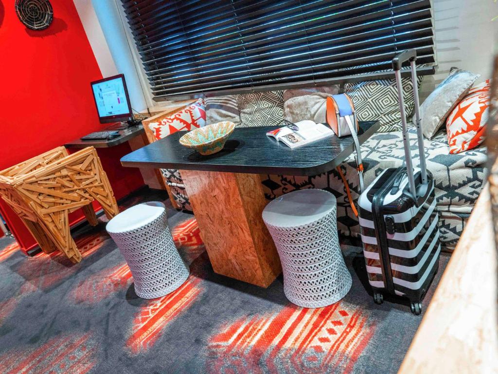 a living room with a table and a couch at ibis Styles Paris Boulogne Marcel Sembat in Boulogne-Billancourt