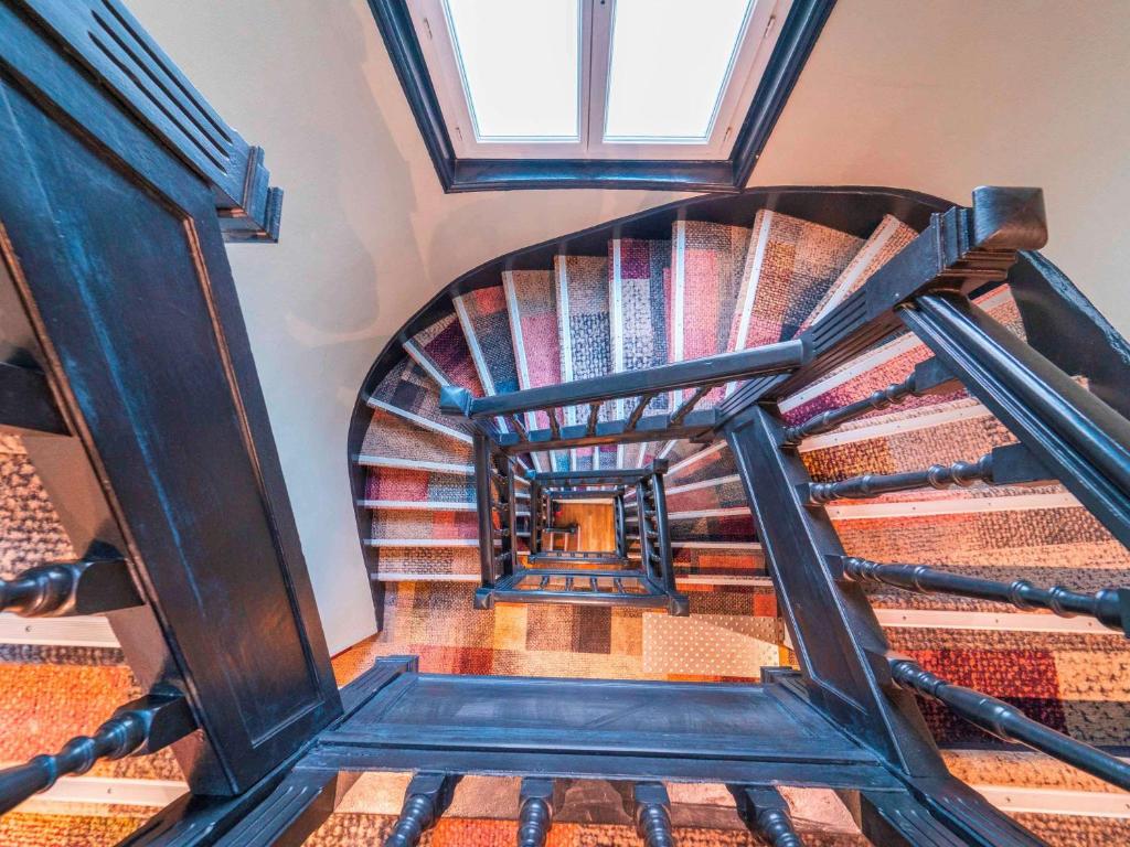 a spiral staircase in a building with a window at ibis Styles Paris Boulogne Marcel Sembat in Boulogne-Billancourt