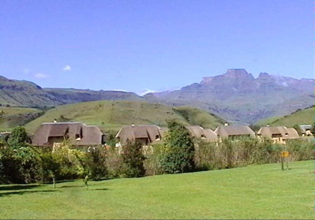un gruppo di case in un campo con montagne sullo sfondo di 10 Mount Champagne a Champagne Valley