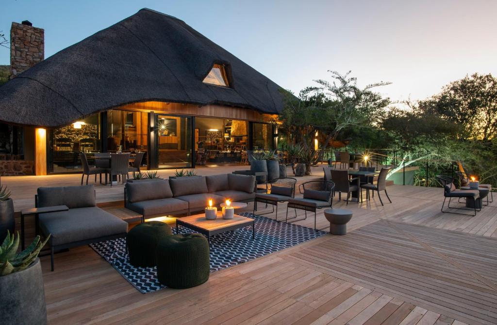 a patio with couches and tables and a restaurant at Shamwari Bayethe in Paterson