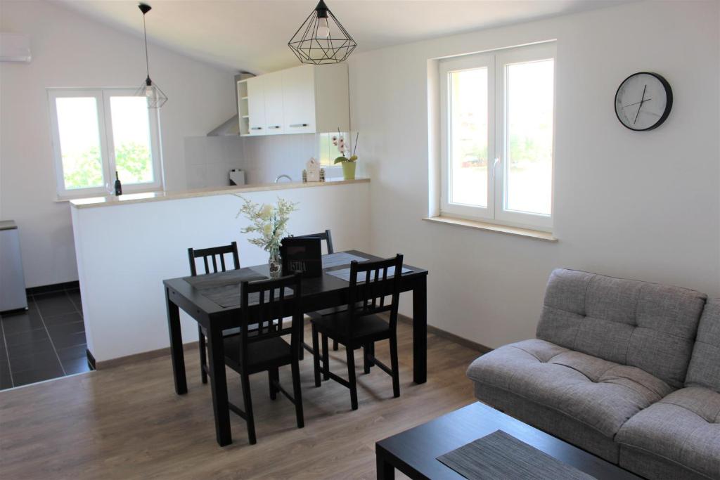 kuchnia i salon ze stołem i krzesłami w obiekcie Horizont Apartman w mieście Kukci