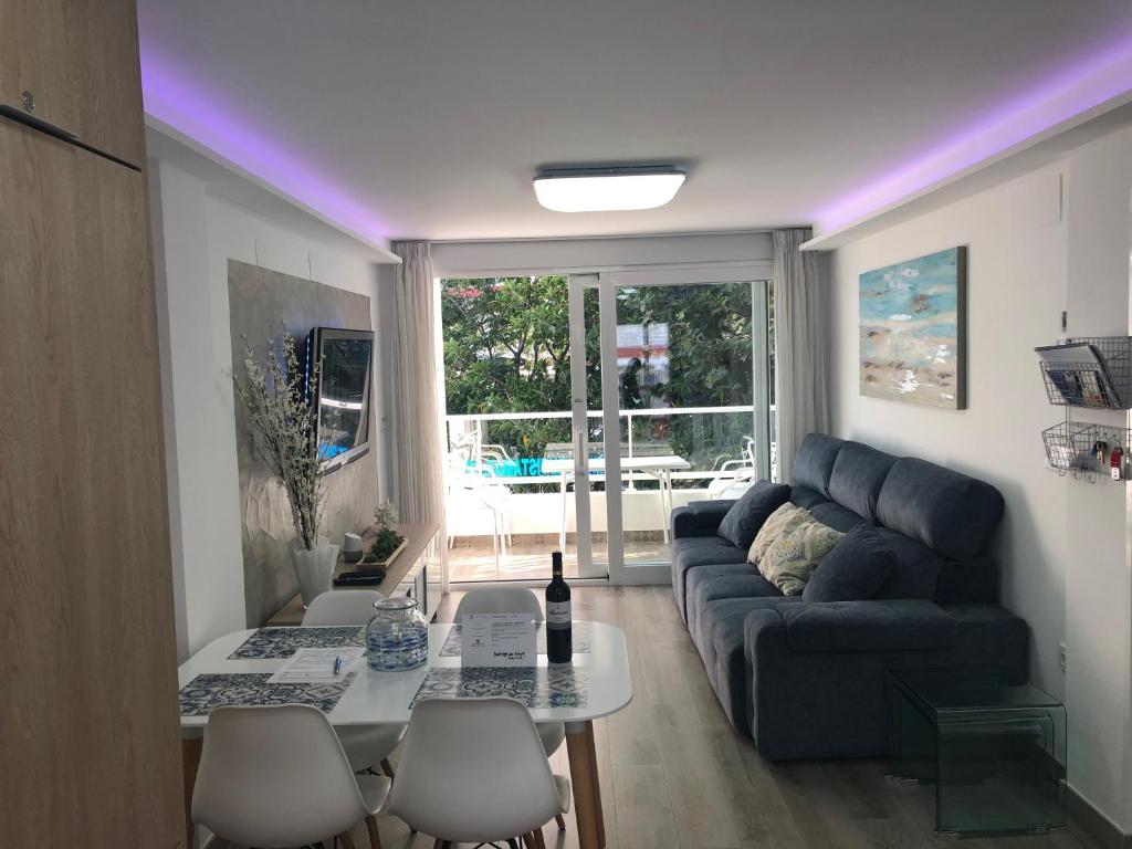 una sala de estar con un sofá y una mesa en Vistamar Beach Luxury - 1ª Línea De Playa En Torre del Mar, Piscina y Apartamiento, en Torre del Mar